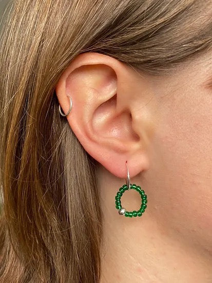 A woman&#39;s ear with a Kākāriki Sleepers hoop earring from Avara Studio.