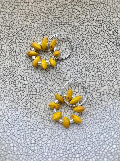 A pair of Avara Studio Kōwhai Circle Sleepers on a grey background.