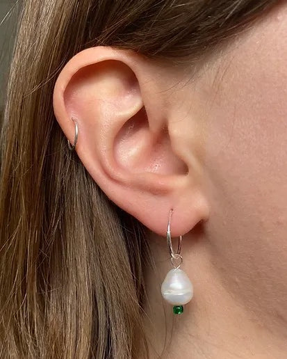 A woman's ear with Pearl Sleepers - Raindrop by Avara Studio.