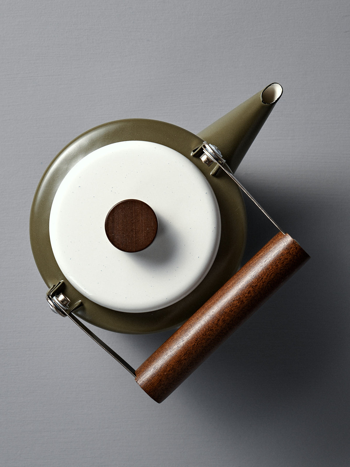 Top view of the Enamel Two-Tone Kettle - Olive Drab, featuring a white lid, dark walnut handle, and olive-green enamelware body on a gray surface.