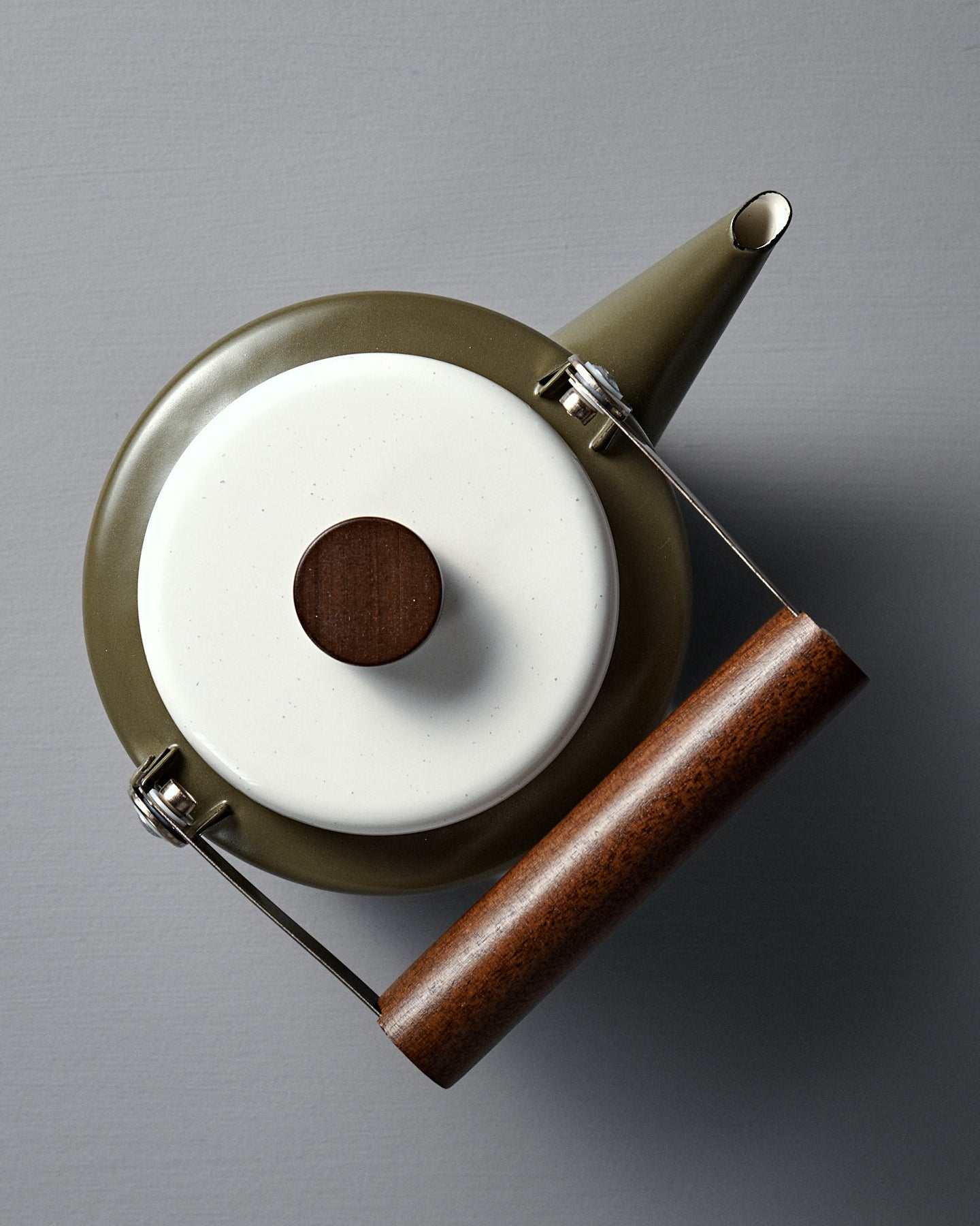 The Enamel Two-Tone Kettle – Olive Drab features a green finish, white lid, and dark walnut handle, displayed on a plain gray background.
