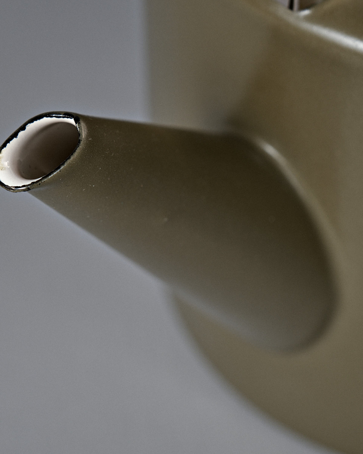 Close-up of an Enamel Two-Tone Kettle – Olive Drab spout against a neutral background, focusing on the detail of the spout's edge and a portion of the kettle's body.