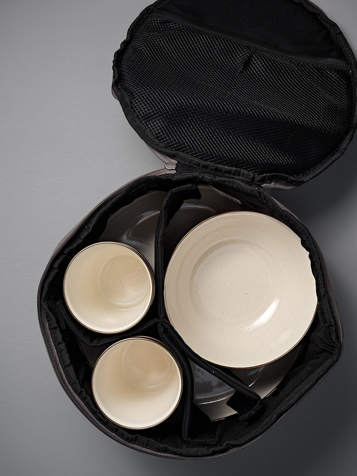 The Barebones Padded Utility Storage Bag features a black interior and padded dividers to securely hold two bowls and two plates—perfect for storing your Barebones enamelware.