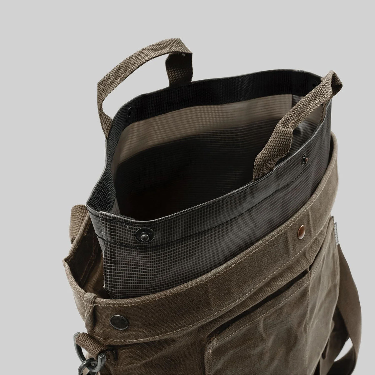 Close-up of an open Gathering Bag – Khaki by Barebones, featuring a vintage orchard design with a brown canvas exterior. It includes a front pocket and two handles, showcasing its black interior lining.