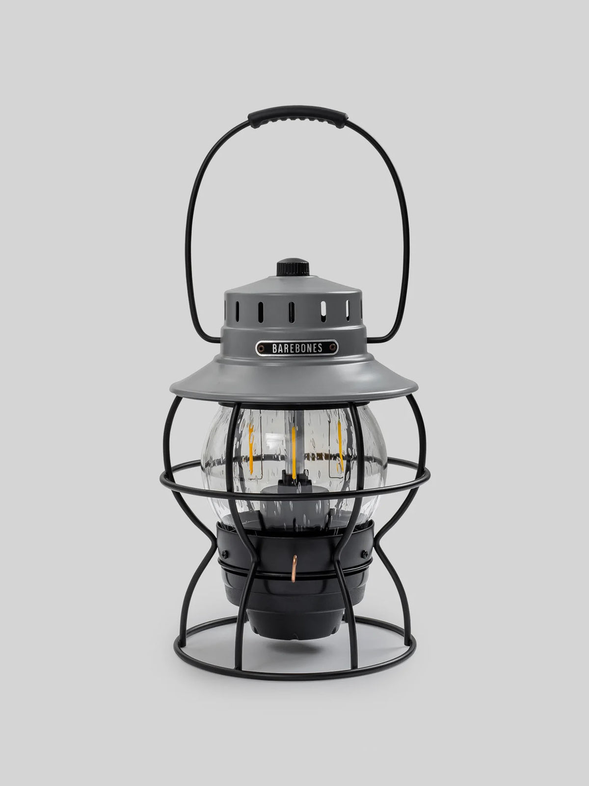 The Railroad Lantern – Slate Grey by Barebones features a clear glass globe, metal frame, and top handle. It includes an Edison-style LED bulb for decorative or functional lighting.