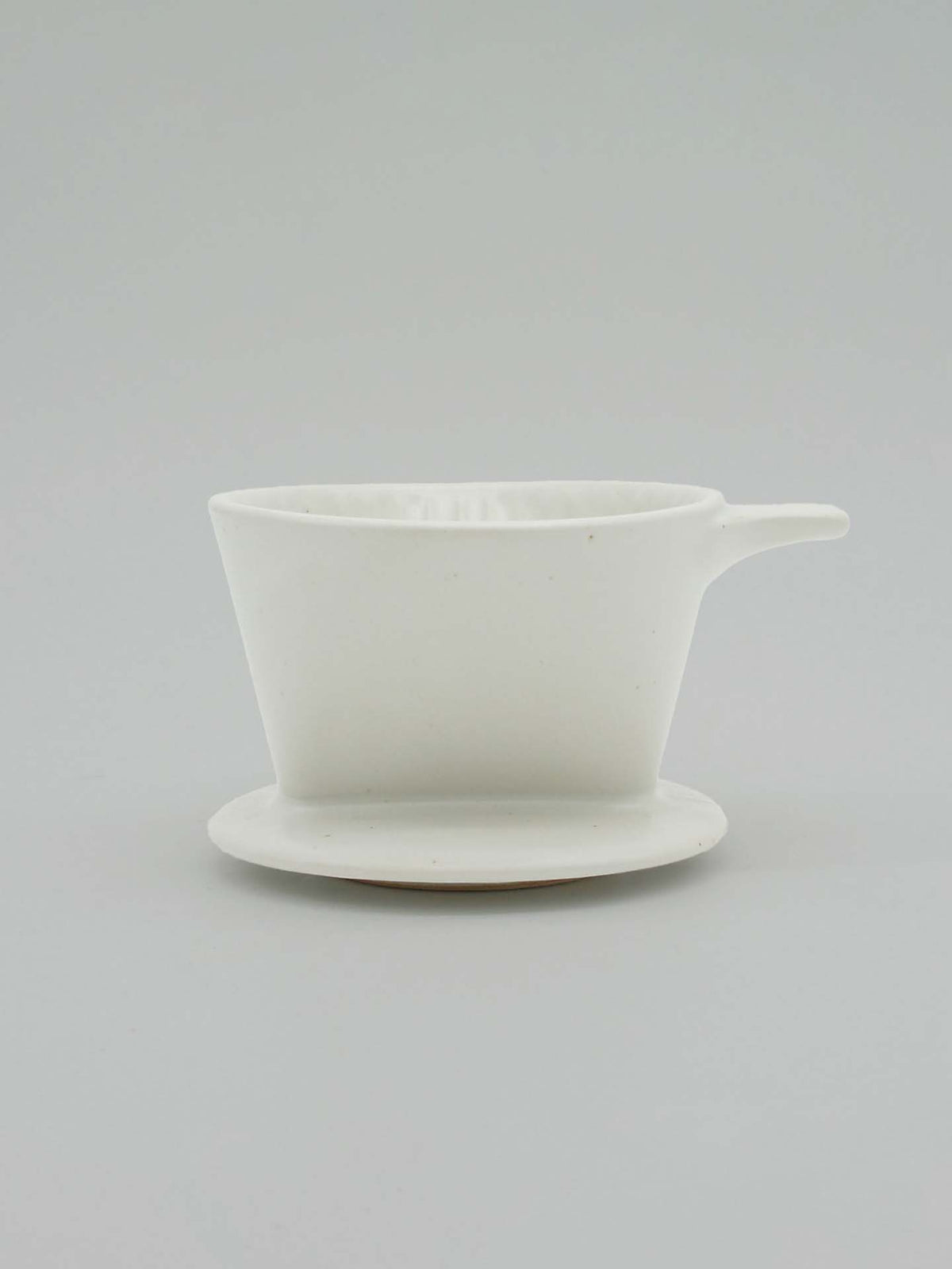 A CHIPS Inc. Mino-yaki Coffee Dripper (2 Cup) in a pristine white finish sits elegantly on a plain gray background, exuding the timeless charm of Japanese craftsmanship.