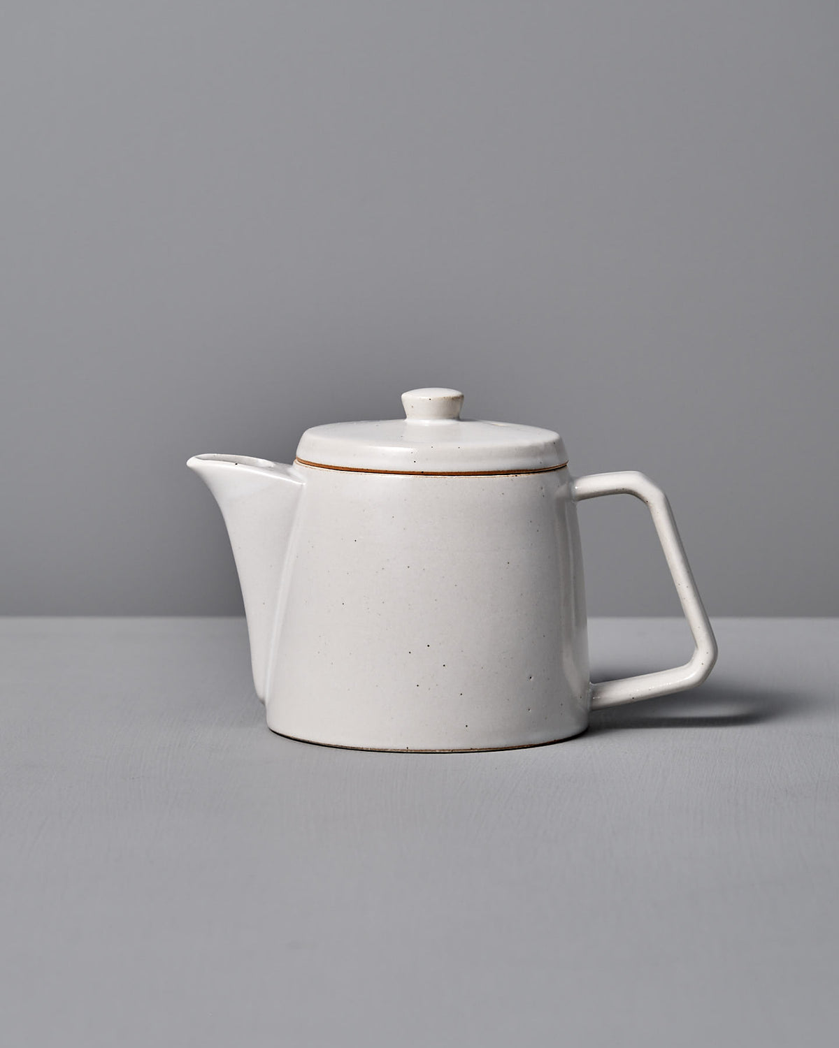 The CHIPS Inc. Mino-yaki Teapot (2 Cup) – White, with a square handle, is elegantly set against a gray background.