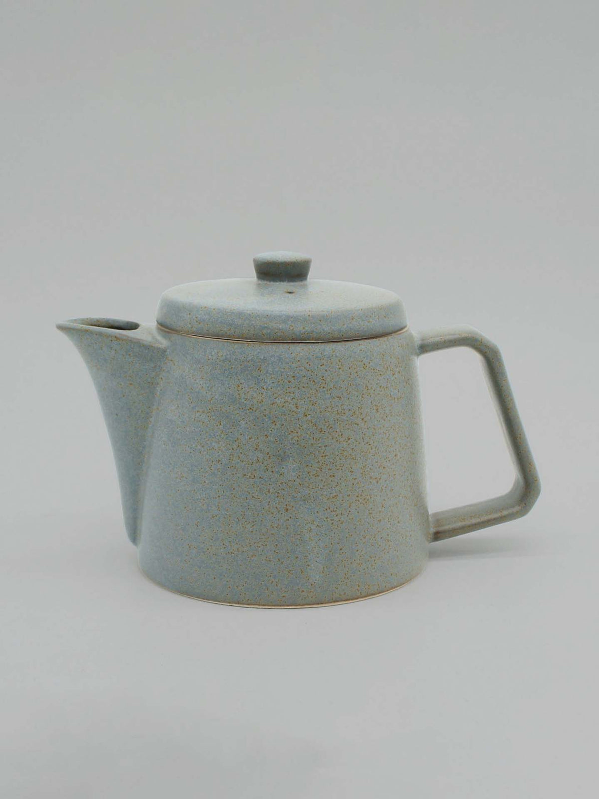 A speckled, light gray CHIPS Inc. Mino-yaki Teapot (2 Cup) with a lid, spout, and angular handle is centered against a plain background. Perfect for brewing loose leaf tea, this teapot combines traditional craftsmanship with timeless elegance.