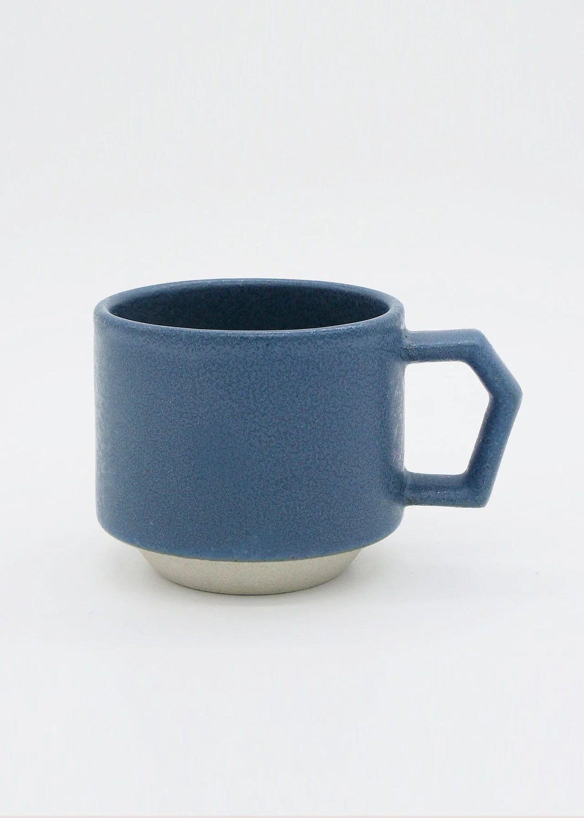 A Stacking Mug - Navy by CHIPS Inc. with a handle on a white background.