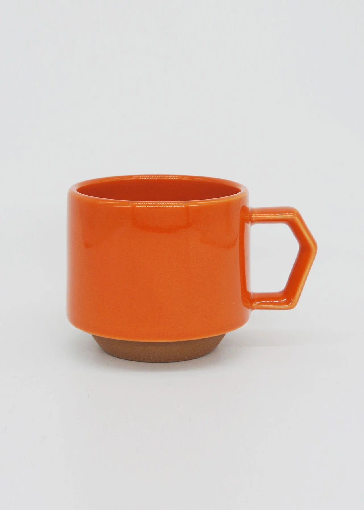 A CHIPS Inc. stackable orange mug with a handle on a white background.