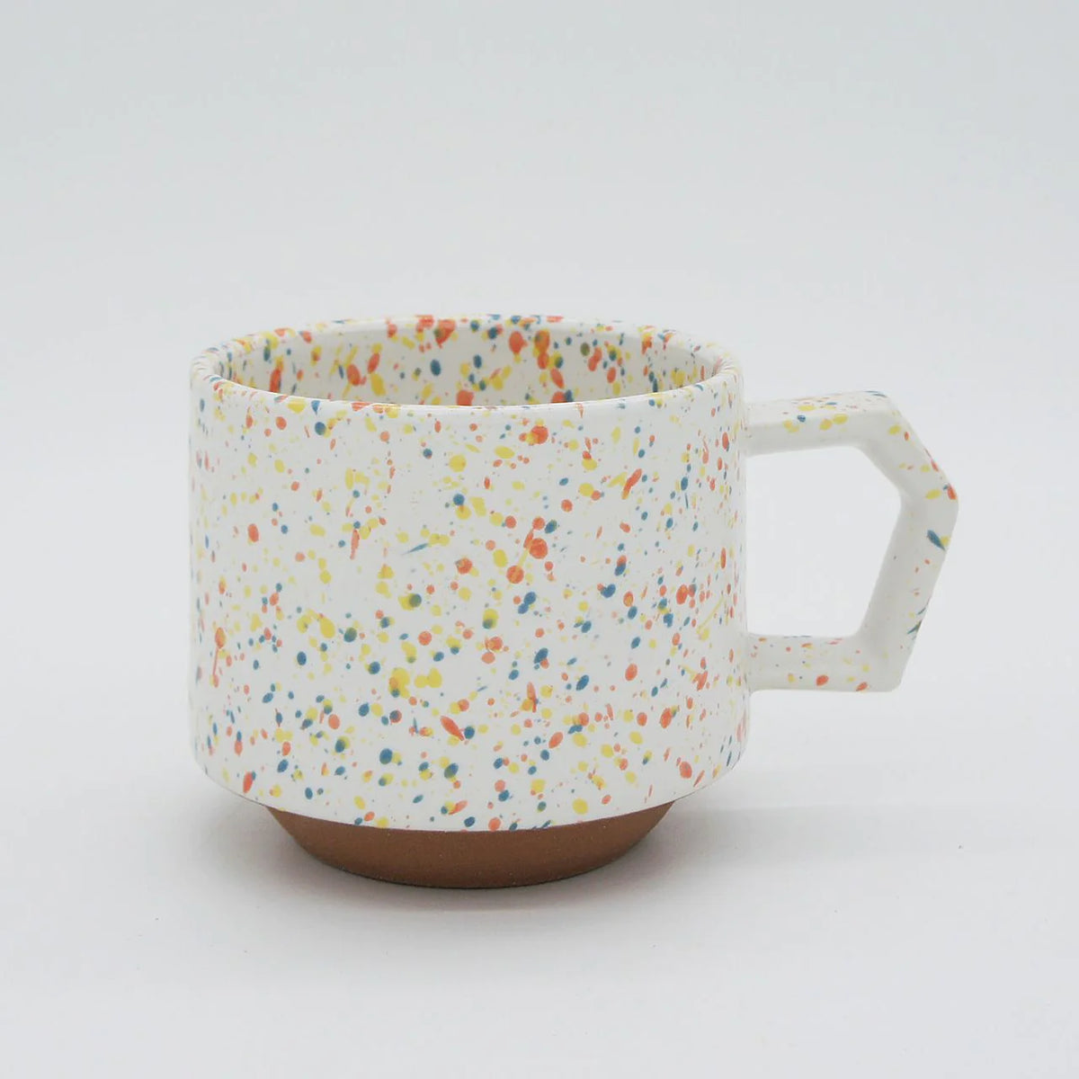 A Stacking Mug - Speckled White with a handle on a white surface.