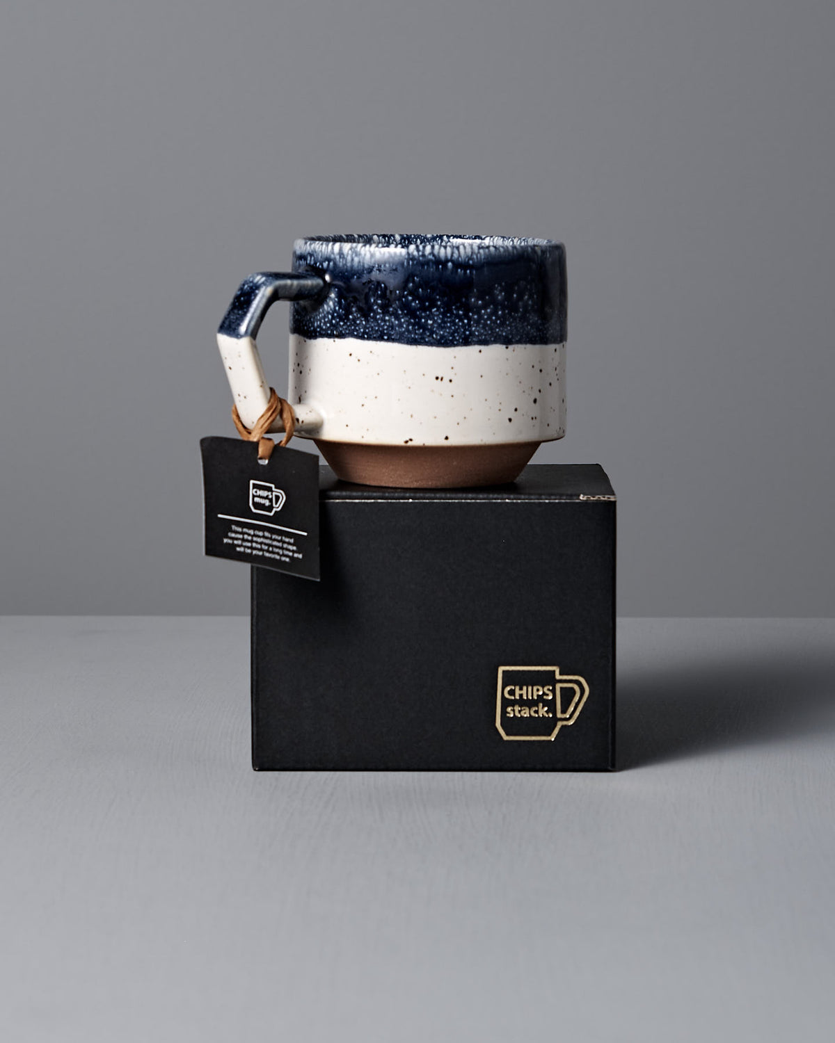 A Stacking Mug – White Navy Drop from CHIPS Inc. sits on a black "Chips Stack" box, with a tag highlighting its stackable design.