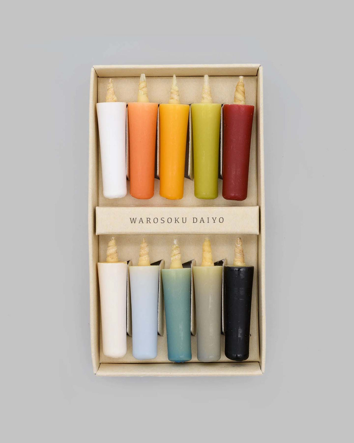 Introducing the "Rice Wax Candle & Ceramic Stand Set – Earth | Black" by Daiyo: a beautifully boxed set featuring eight vibrant Japanese candles, each boasting a unique hue, crafted from rice wax to enhance your meditation experience.