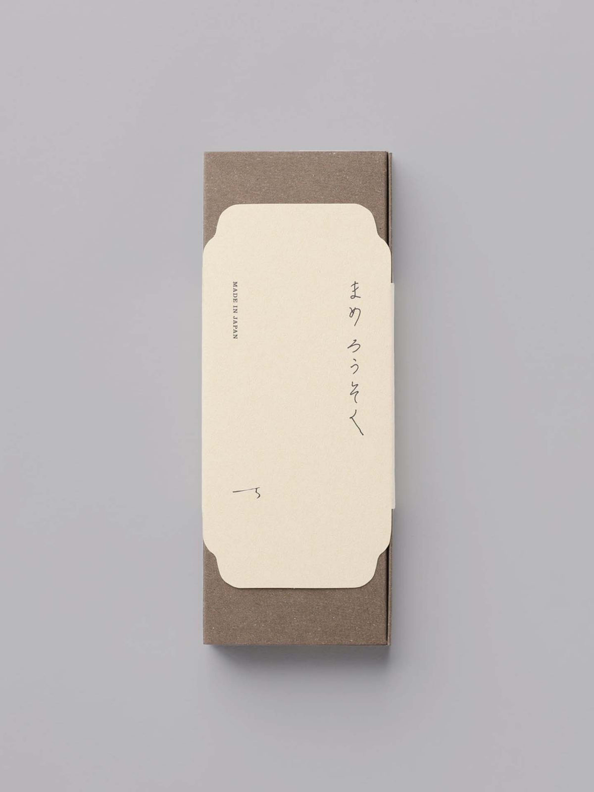 A closed envelope with Japanese text on a gray background, reminiscent of the serenity evoked by Daiyo&#39;s Rice Wax Candle &amp; Ceramic Stand Set – Earth | Black.