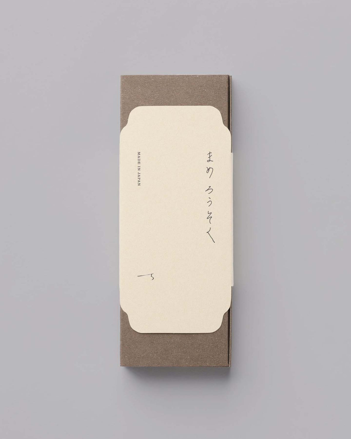 A closed envelope with Japanese text on a gray background, reminiscent of the serenity evoked by Daiyo's Rice Wax Candle & Ceramic Stand Set – Earth | Black.