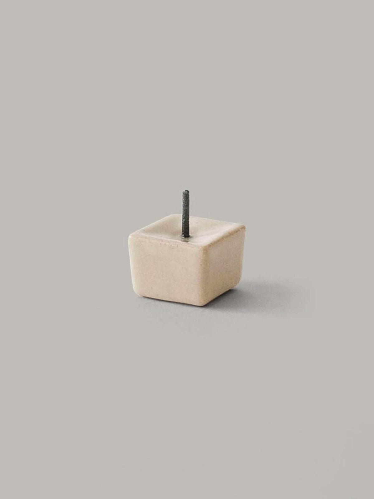 The Daiyo Rice Wax Candle &amp; Iron Stand 20pc Box Set in Black, White, and Beige features a compact iron and ceramic candle stand with a square shape and a single short rod on top, beautifully showcased against a plain gray background.