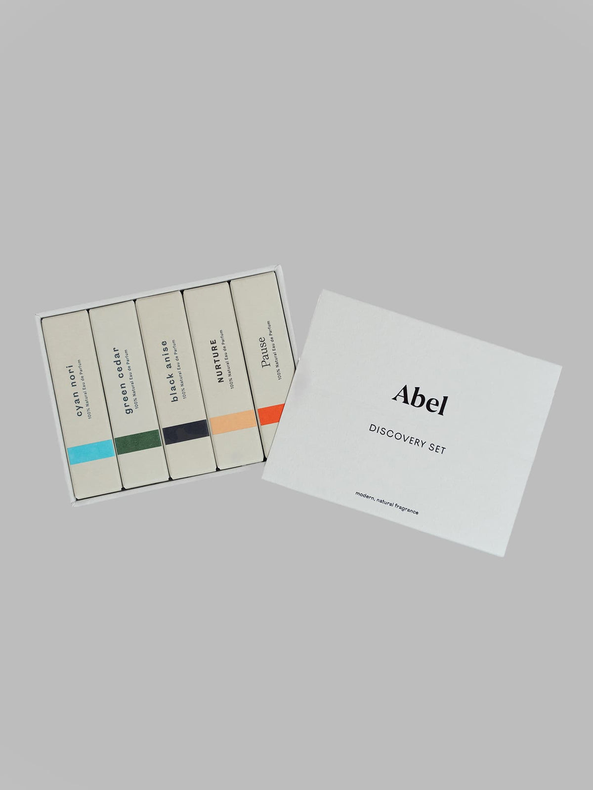 A box labeled &quot;Abel Discovery Set – 5 most popular scents&quot; is open, revealing five smaller boxes inside, each containing a 100% natural scent: Cyan Nori, Green Cedar, Pink Iris, Nurture, and Pause.