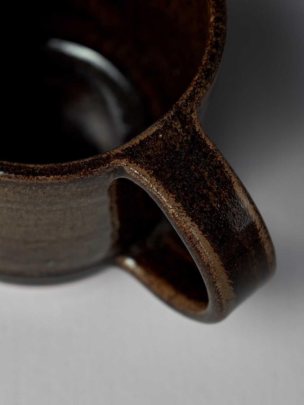 Close-up of the Studio Foon Everyday Stacker Cup – Large in Burnt Umber, highlighting the handle and rim against a softly blurred white background.