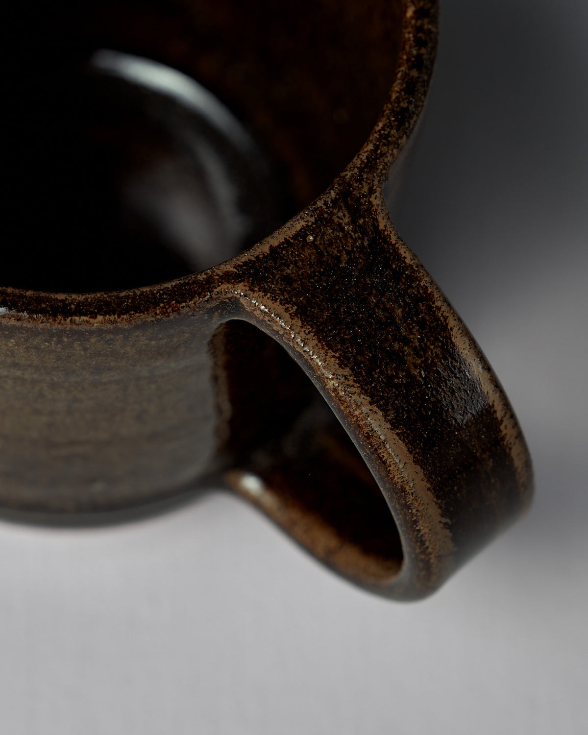 Close-up of the Studio Foon Everyday Stacker Cup – Large in Burnt Umber, highlighting the handle and rim against a softly blurred white background.
