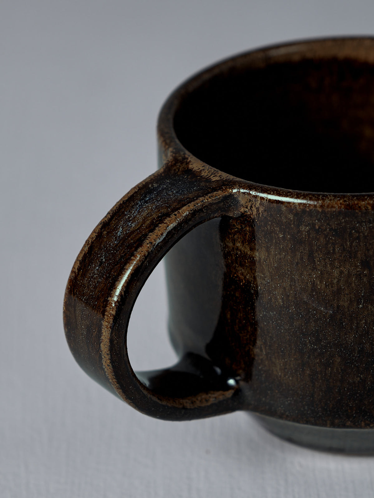 Close-up of the handle and rim of Studio Foon&#39;s Everyday Stacker Cup – Medium in Burnt Umber, shown against a plain light background.