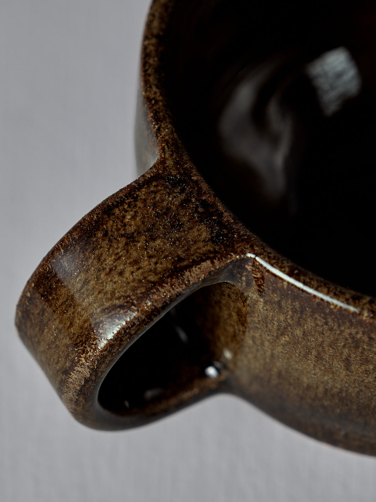 Close-up of the Everyday Stacker Cup – Small in Burnt Umber, showcasing its glossy brown handcrafted handle, rim, and inner surface against a neutral background—ideal for daily use.