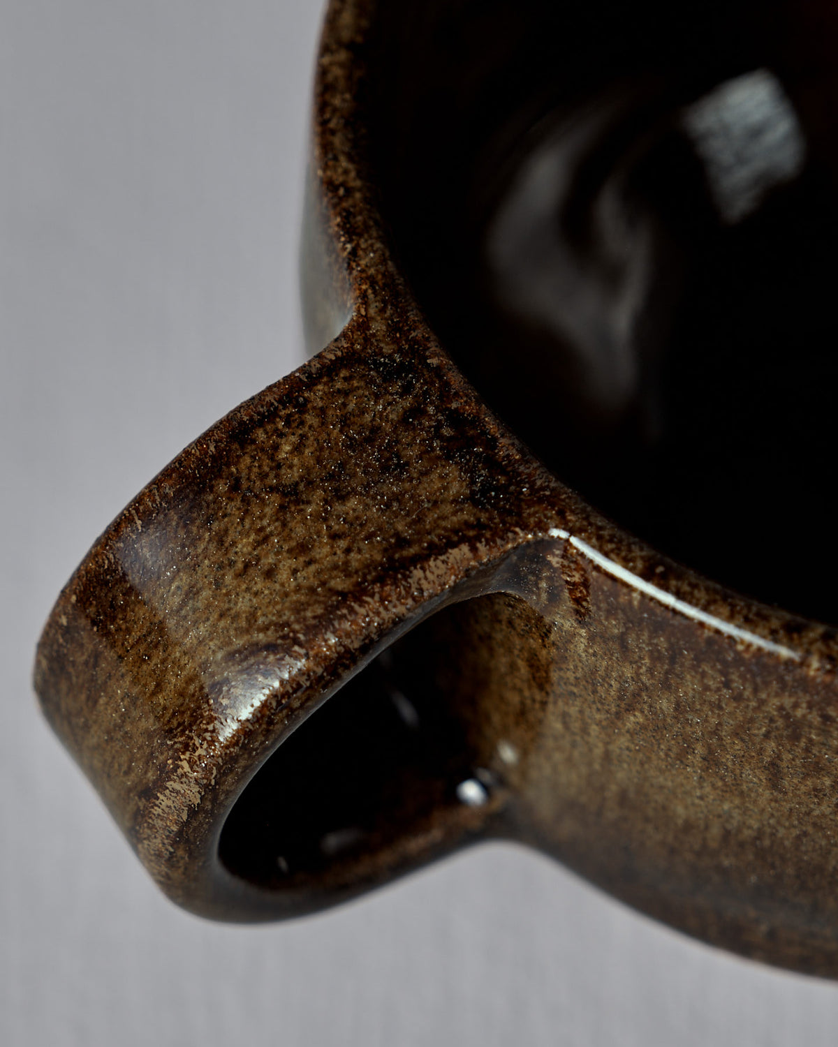 Close-up of the Everyday Stacker Cup – Small in Burnt Umber, showcasing its glossy brown handcrafted handle, rim, and inner surface against a neutral background—ideal for daily use.