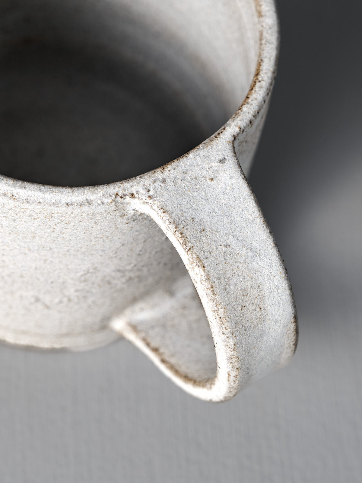 Close-up of the Studio Foon Everyday Stacker Cup – Large in Stone White, highlighting its speckled finish, rim, handle, and interior against a neutral backdrop—perfect for elevating your daily cup experience.