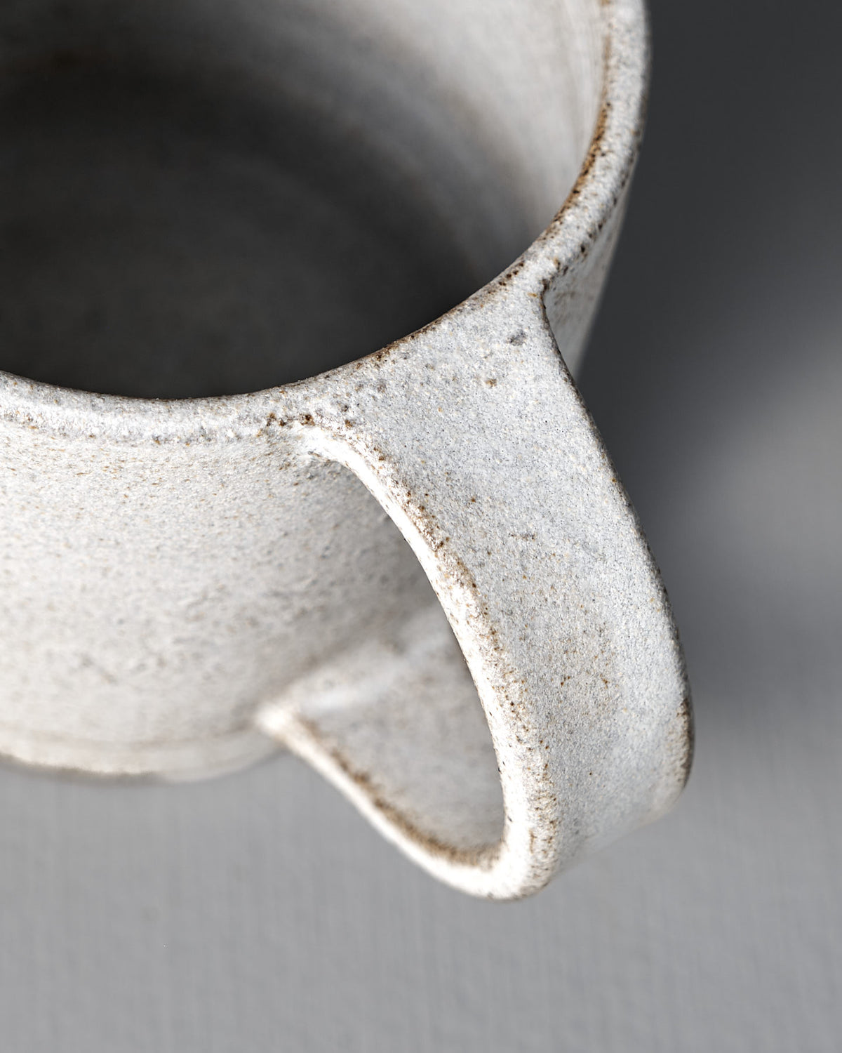 Close-up of the Studio Foon Everyday Stacker Cup – Large in Stone White, highlighting its speckled finish, rim, handle, and interior against a neutral backdrop—perfect for elevating your daily cup experience.