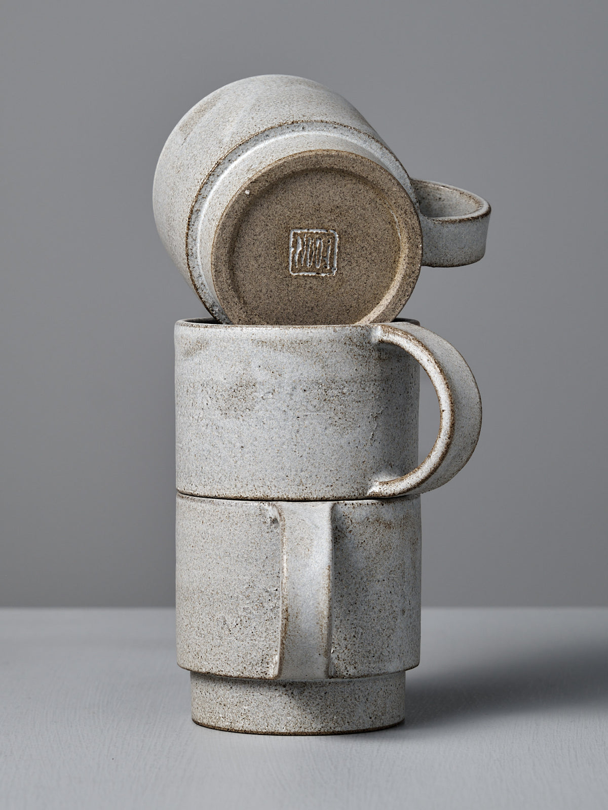 Three Studio Foon Everyday Stacker Cup – Large | Stone White cups are shown: two upright and one 300ml cup upside down on top, all arranged against a plain gray background.