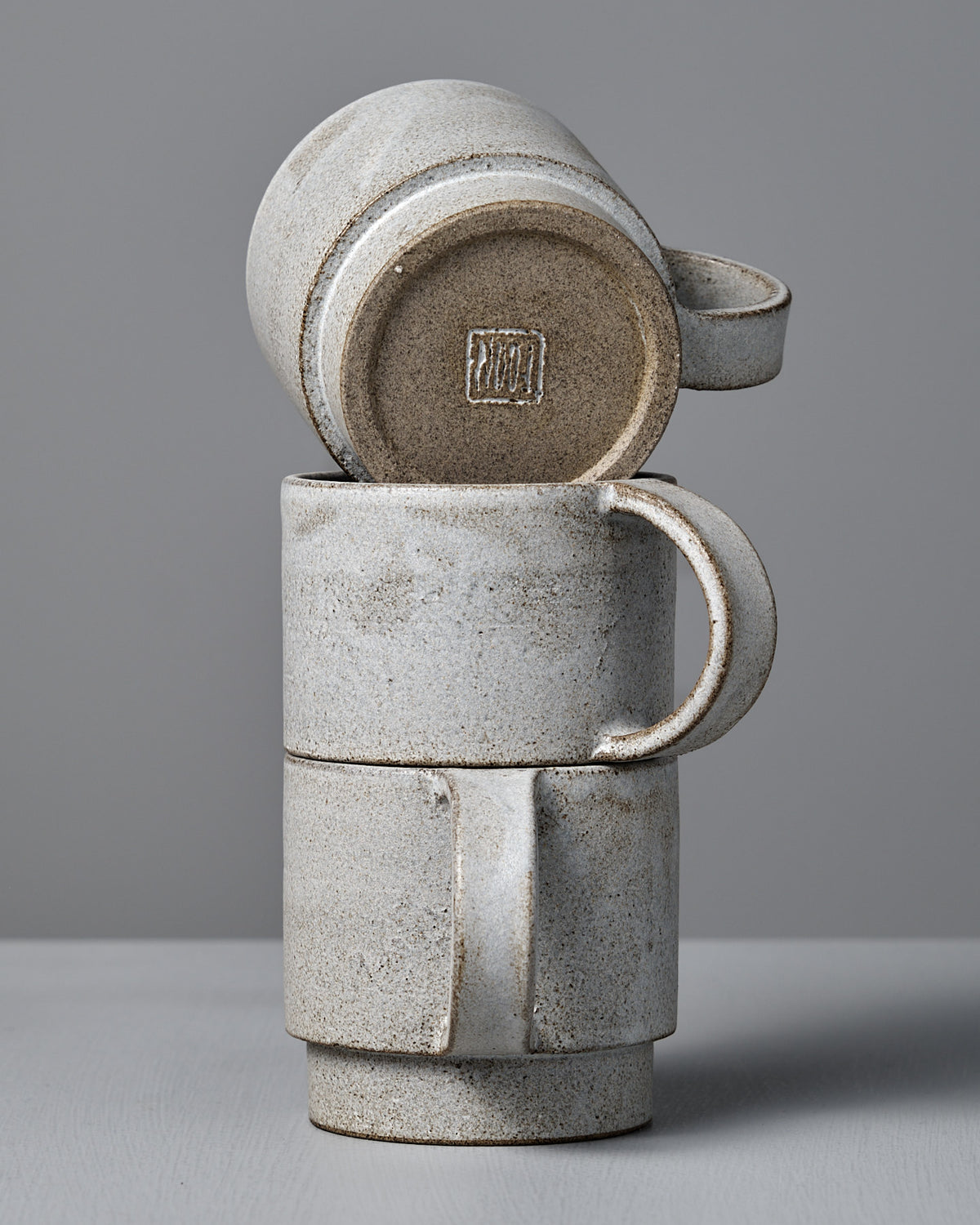 Three Studio Foon Everyday Stacker Cup – Large | Stone White cups are shown: two upright and one 300ml cup upside down on top, all arranged against a plain gray background.