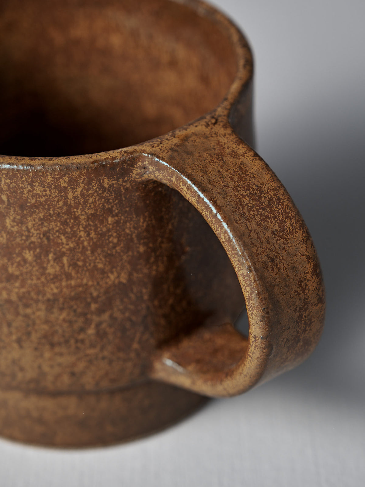 Close-up of the Studio Foon Everyday Stacker Cup – Large in terracotta, featuring a textured brown handcrafted design with a sturdy handle, set against a plain light background.