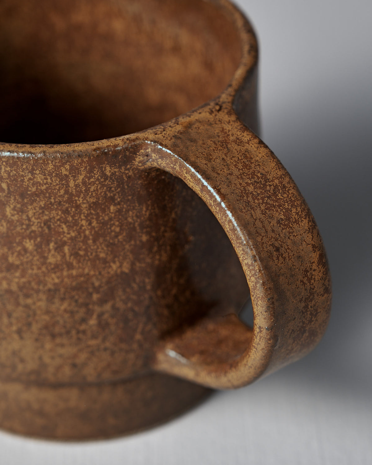 Close-up of the Studio Foon Everyday Stacker Cup – Large in terracotta, featuring a textured brown handcrafted design with a sturdy handle, set against a plain light background.