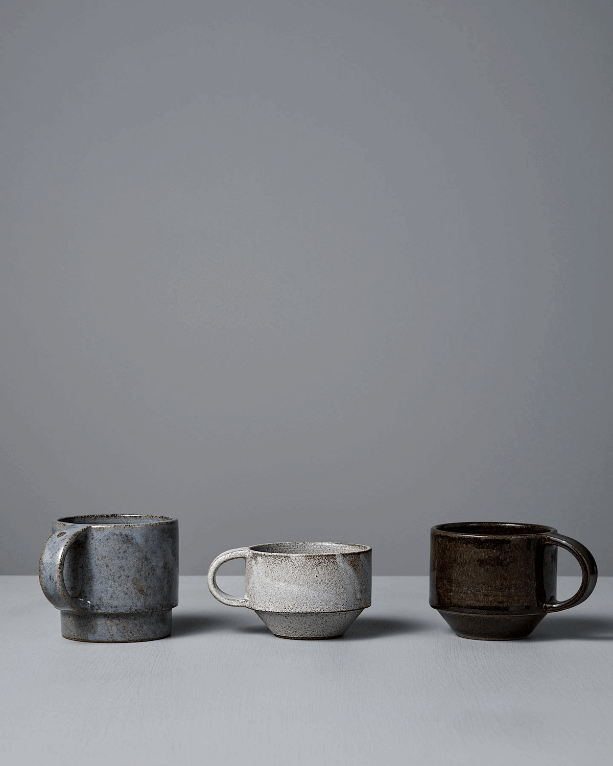 The Studio Foon Everyday Stacker Cup – Large in Stone White is a handcrafted cup, shown on a light gray surface with a plain gray background, perfect as your new go-to coffee cup.