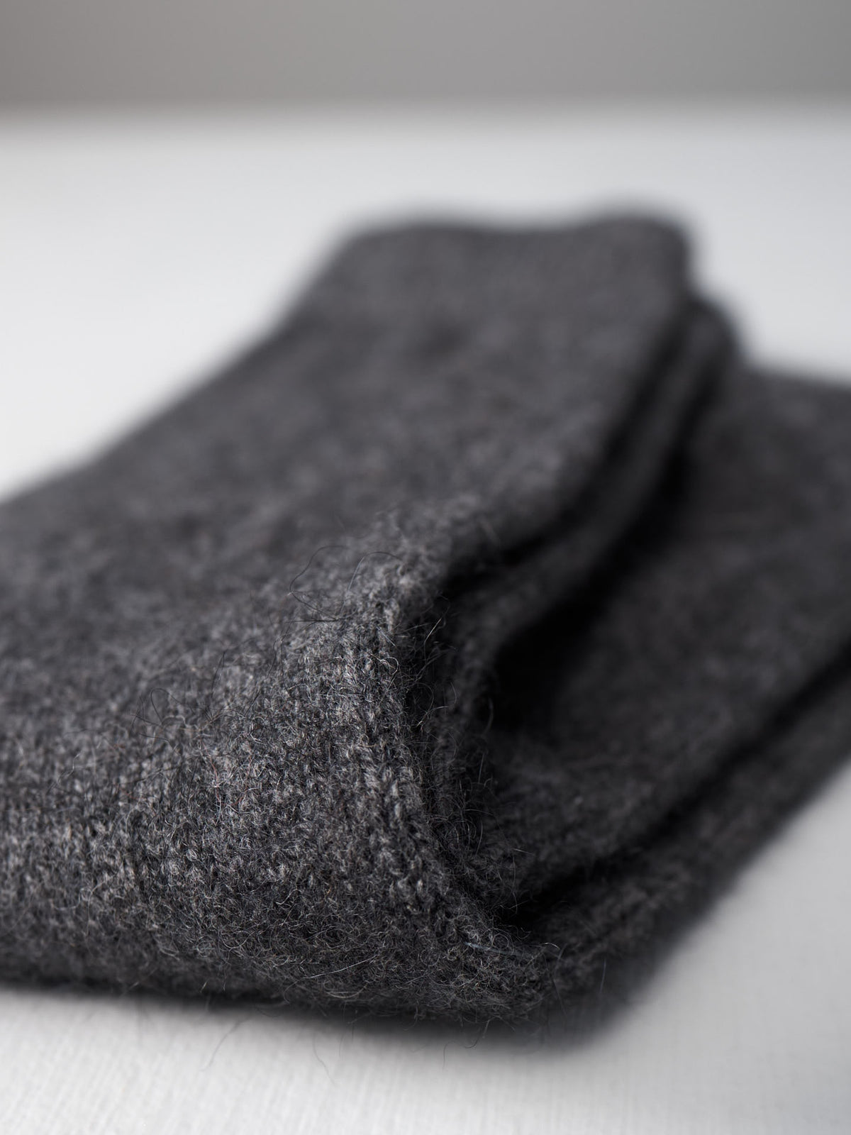 A close-up of Francie&#39;s Possum Merino Socks in Charcoal on a white surface, available in small, medium, and large. The perfect addition to any outfit—see our UK US EUR size guide for your best fit.