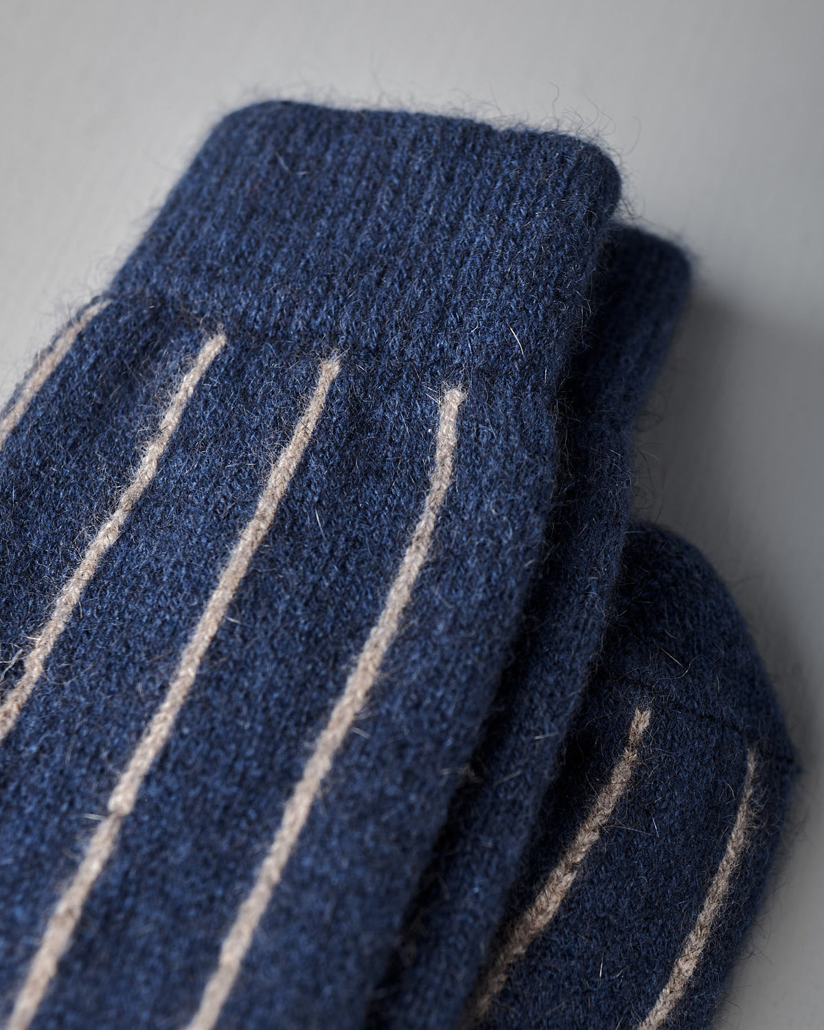 Close-up of Francie's Possum Merino Socks – Blue & Natural Stripe on a light gray surface, available in small, medium, and large sizes—see our sock size chart for the perfect fit.