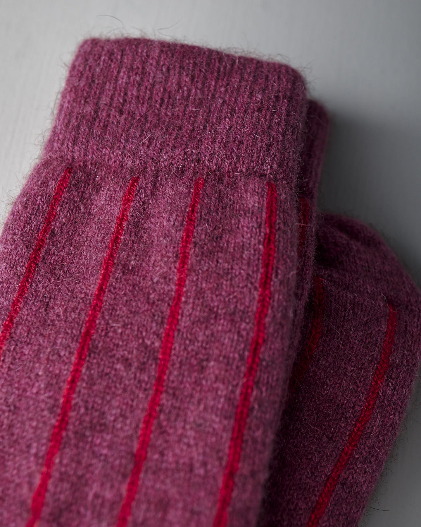 A pair of Francie Possum Merino Socks in Orchid & Poppy Stripe, displayed on a light grey background.