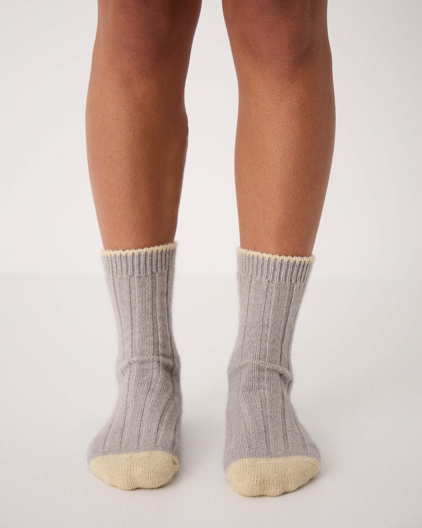 The Yin & Yang Socks – Pearl & Creme Toe feature a gray ribbed design with beige toes and cuffs, displayed on a wooden floor—perfect for easy EU, UK, and US size conversion seekers.