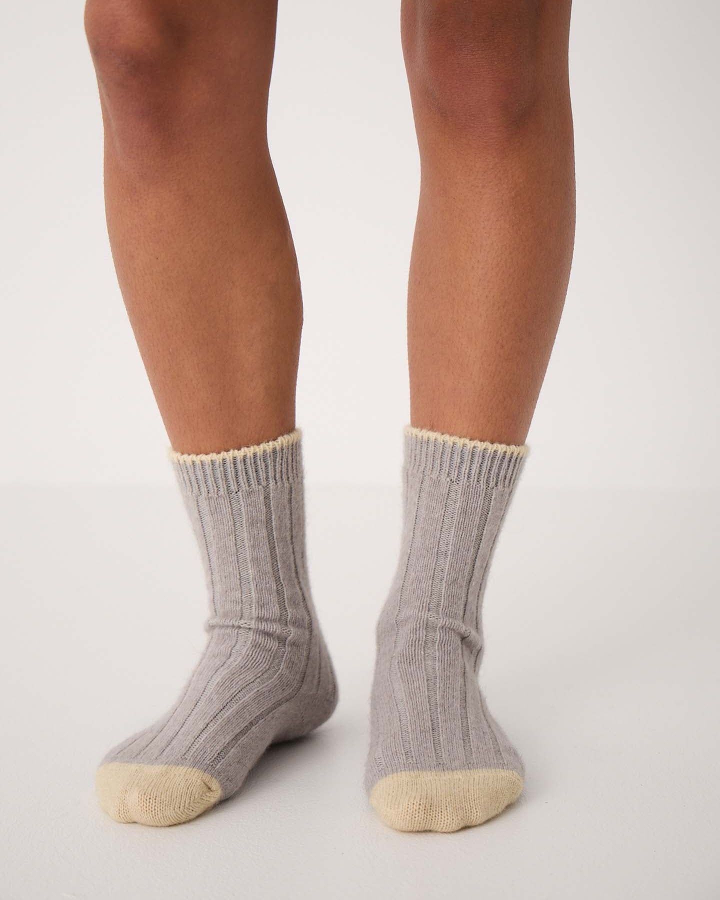 The Yin & Yang Socks – Pearl & Creme Toe feature a gray ribbed design with beige toes and cuffs, displayed on a wooden floor—perfect for easy EU, UK, and US size conversion seekers.