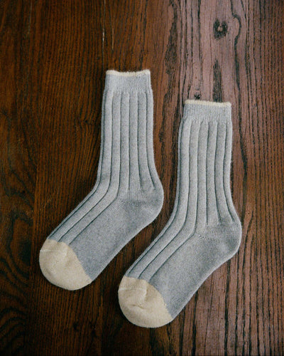 The Yin & Yang Socks – Pearl & Creme Toe feature a gray ribbed design with beige toes and cuffs, displayed on a wooden floor—perfect for easy EU, UK, and US size conversion seekers.