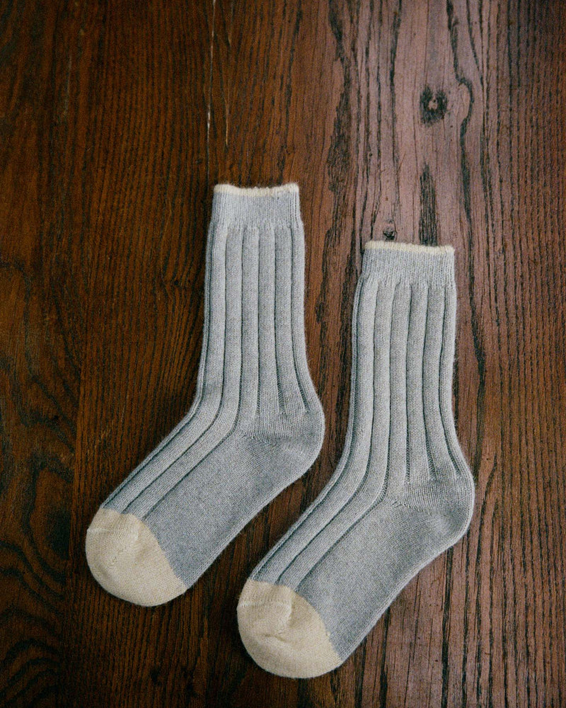 The Yin & Yang Socks – Pearl & Creme Toe feature a gray ribbed design with beige toes and cuffs, displayed on a wooden floor—perfect for easy EU, UK, and US size conversion seekers.