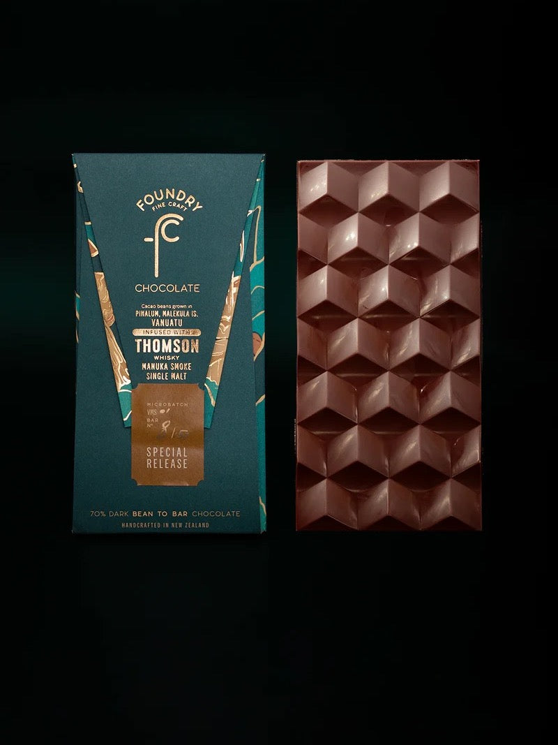 A decadent Foundry Chocolate – Vanuatu x Thomson Manuka Smoke Whisky 70% bar, showcased on a sleek black background.