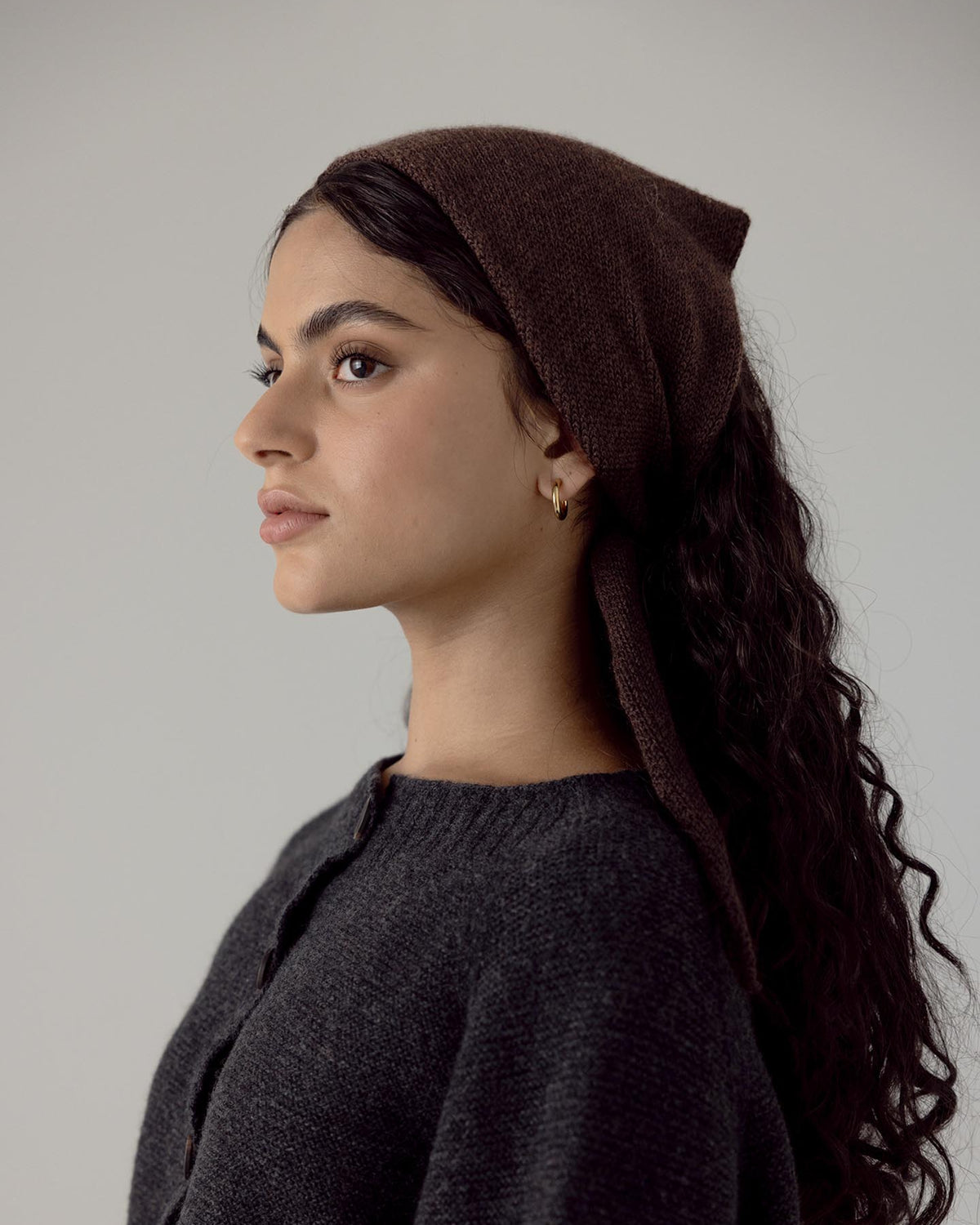 A woman wearing a Daisy scarf – Cocoa and black sweater by Francie.