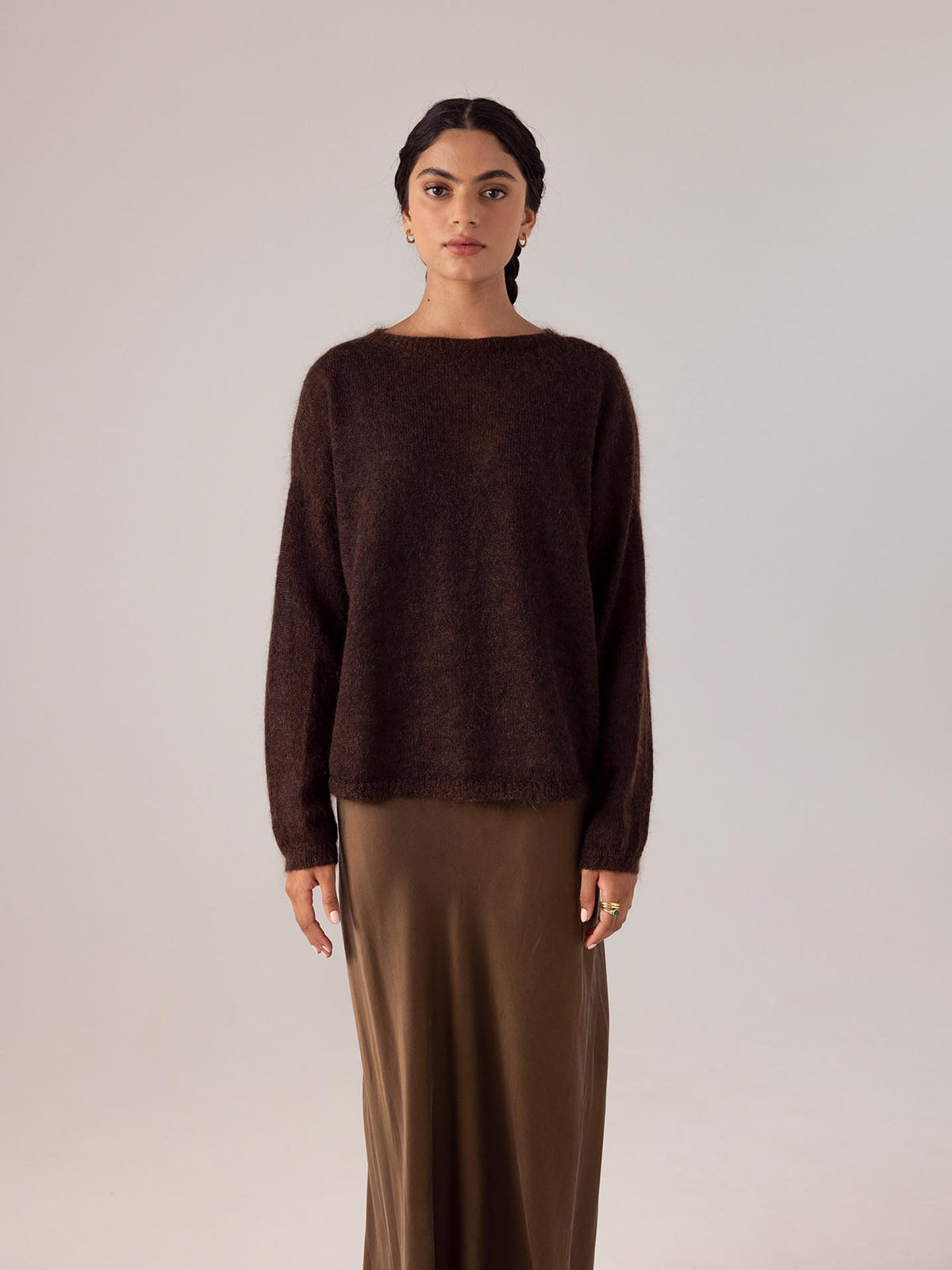 The model is wearing a Francie Cocoa feather knit sweater and tan skirt.