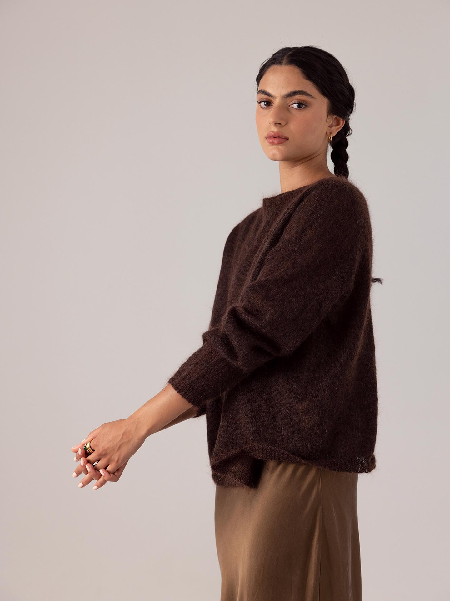 The model is wearing a Francie Feather Knit - Cocoa sweater and a tan skirt.