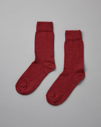 A pair of Francie Possum Merino Socks – Crimson, suitable for various shoe sizes, laid flat on a light beige background.