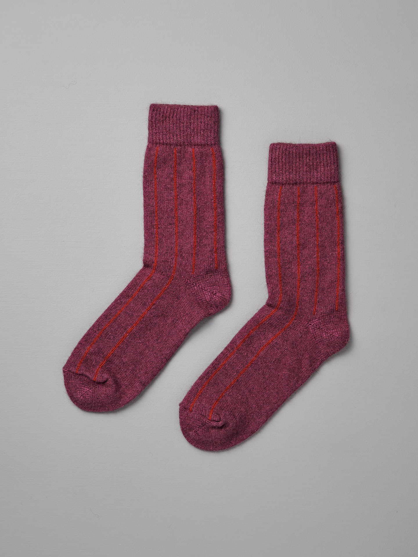 A pair of Francie Possum Merino Socks in Orchid & Poppy Stripe, displayed on a light grey background.