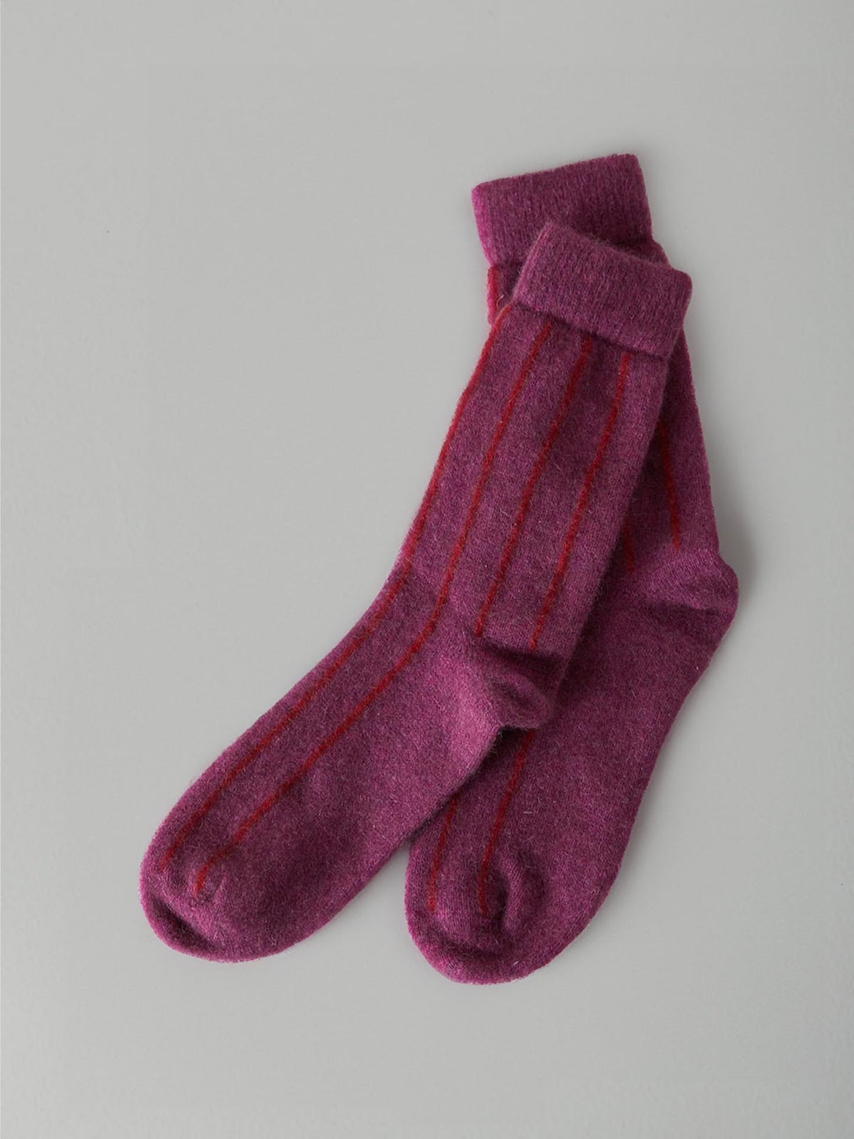 A pair of folded Possum Merino Socks – Orchid &amp; Poppy Stripe by Francie displayed against a light gray background.