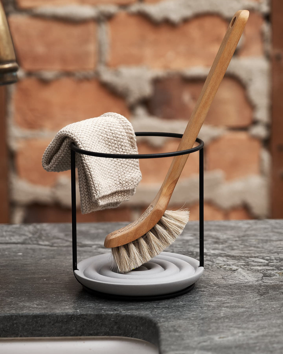 An Iris Hantverk Dish Brush Holder with a cloth in a holder.
