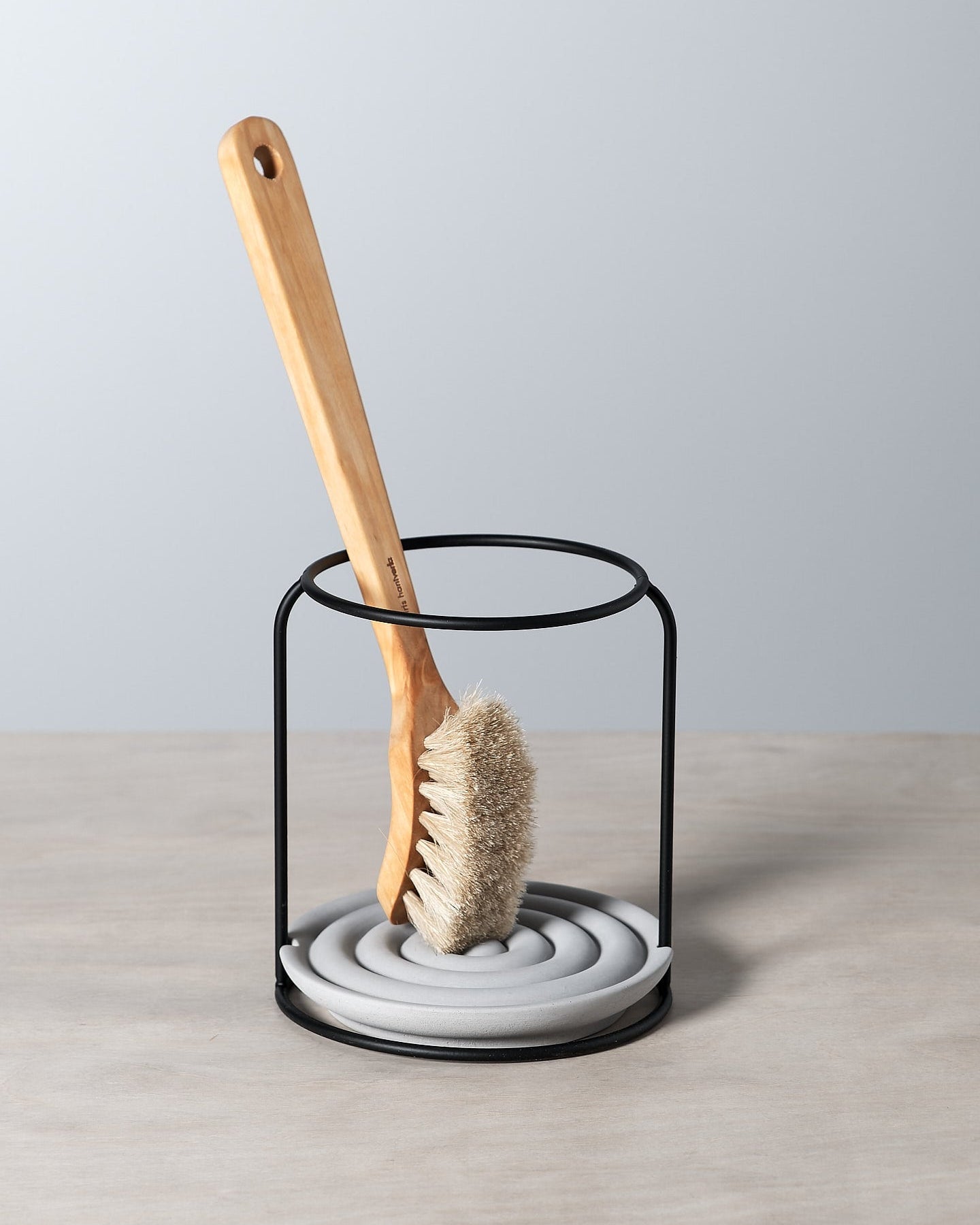 An Iris Hantverk dish brush holder on a table.