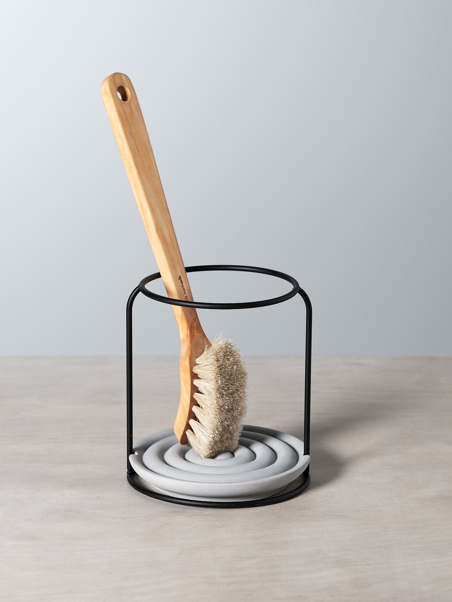 An Iris Hantverk dish brush holder on a table.